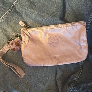 Kipling metallic lilac pouch 5”x8.5”; new. Interior zipper pocket, wrist strap